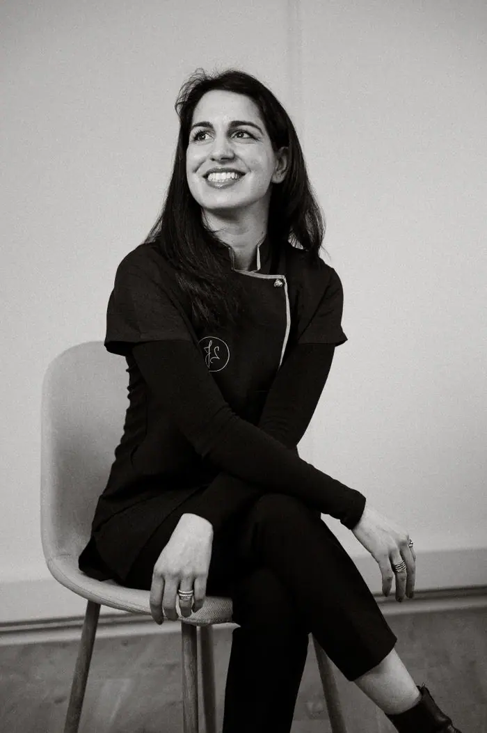 Juliana Santos, fundadora e diretora técnica, sentada e a sorrir, retrato a preto e branco